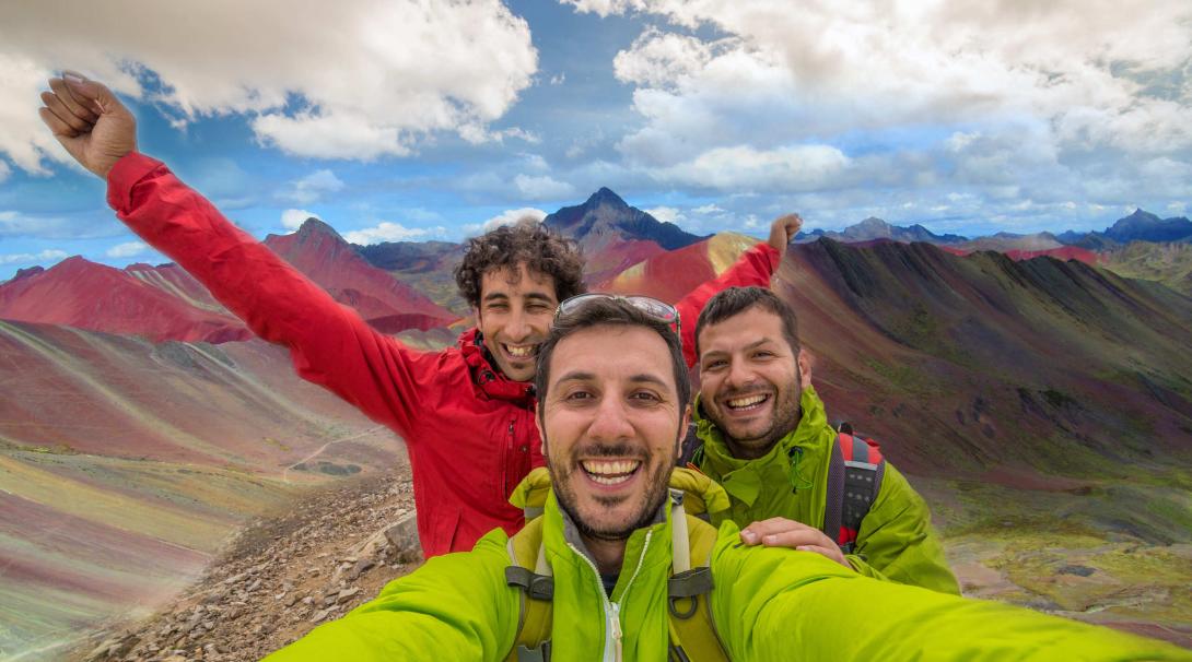 Projects Abroad volunteers discover how travel changed them in 2020. Travellers take a selfie with the Rainbow Mountains of Peru in the background.